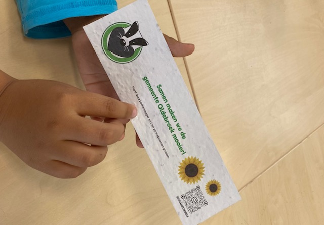 Foto: Duurzaam Oldebroek deelt boekenleggers met zonnebloemzaadjes uit op Dalton Kindcentrum de Wereldweide