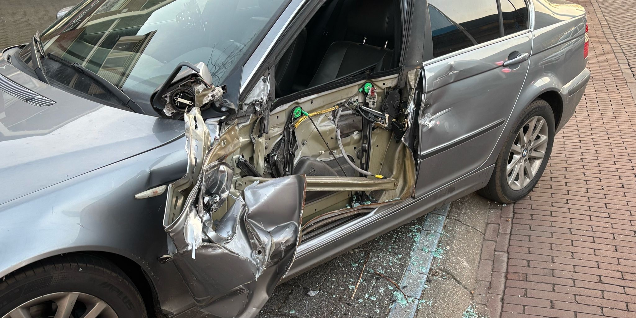 Foto: Vrachtwagenchauffeur draait verkeerd in en ramt geparkeerde BMW bij Albert Heijn