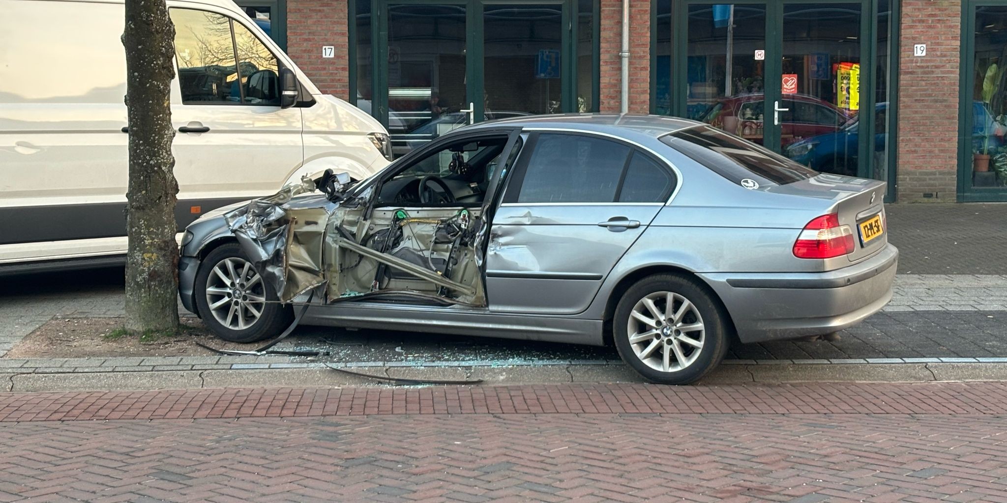 Foto: Vrachtwagenchauffeur draait verkeerd in en ramt geparkeerde BMW bij Albert Heijn