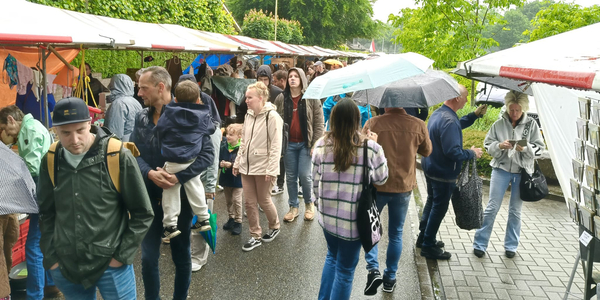 Foto: Mensen uit verschillende streken op regenachtige Hemelvaartmarkt