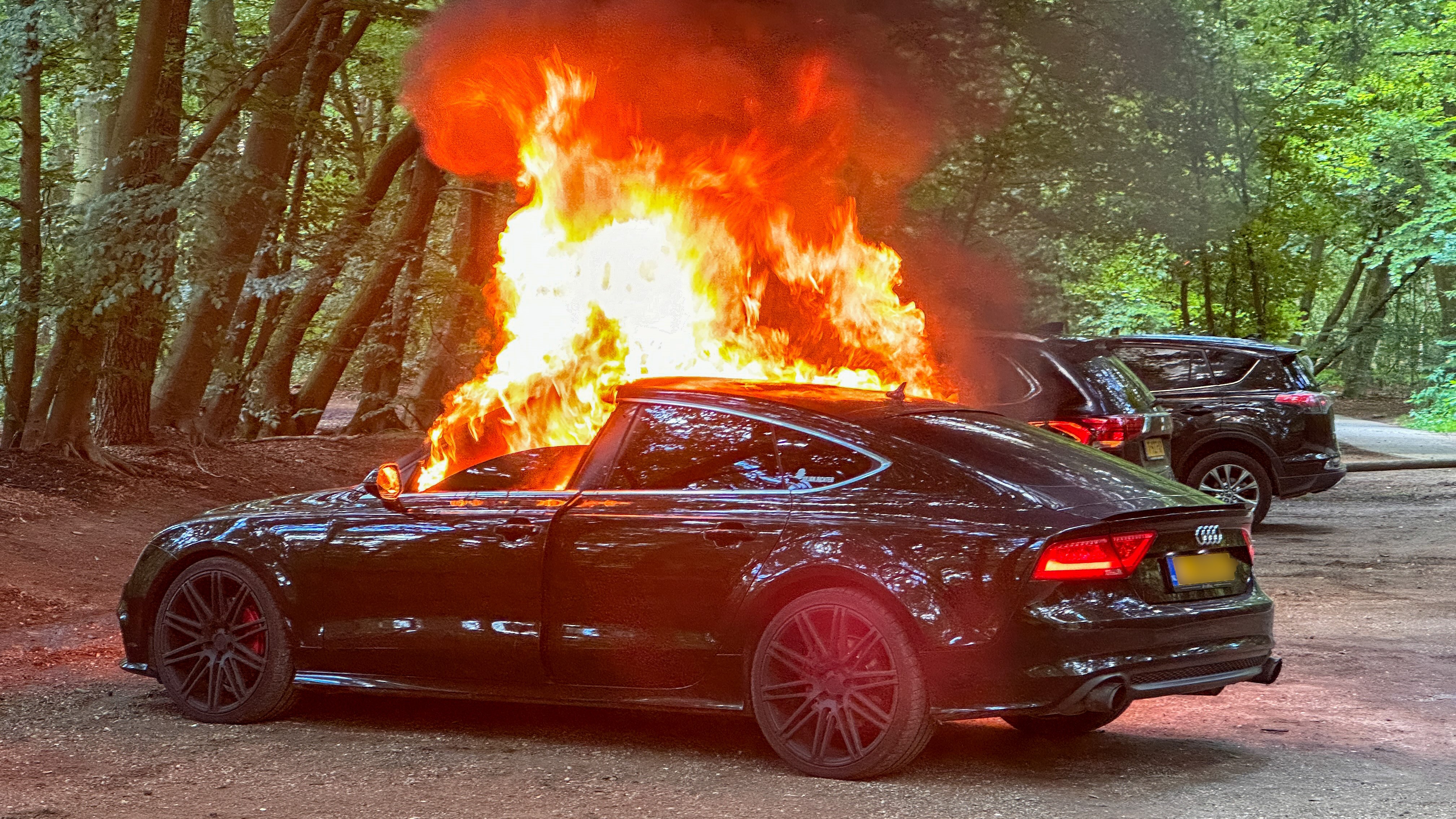 Foto: Auto aan de kant gezet voor lege band, maar vat ook vlam