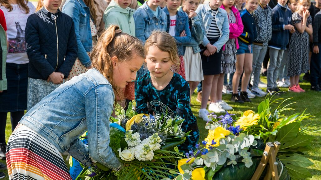 Foto: Kinderen herdenken bij monument begraafplaats De Plantage
