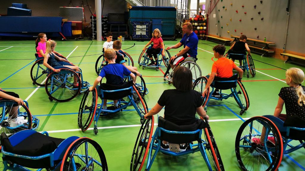 Foto: Basketballen vanuit een rolstoel, paralympiër geeft les