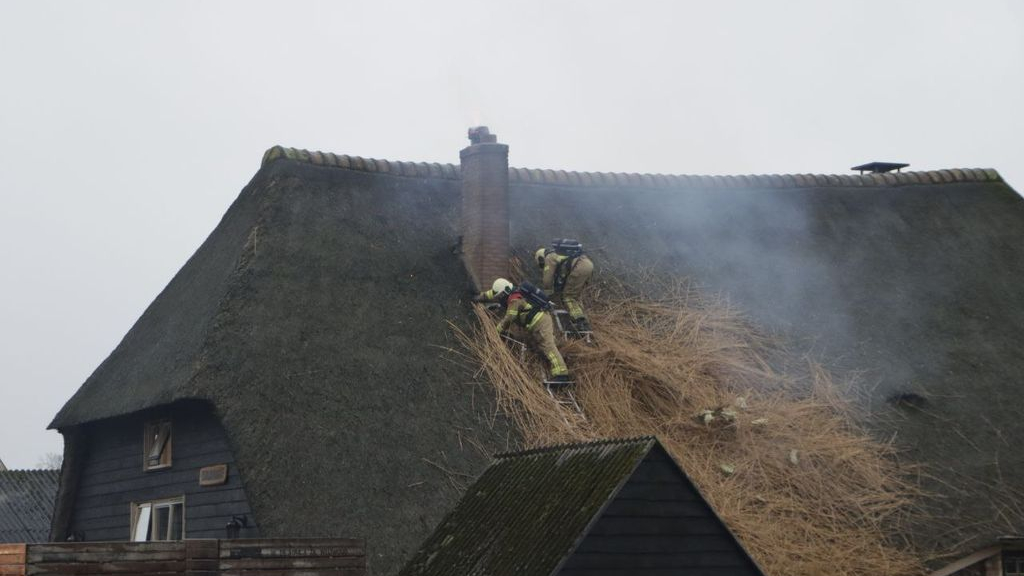 Foto: Schoorsteenbrand bij huis met rieten dak in Hierden